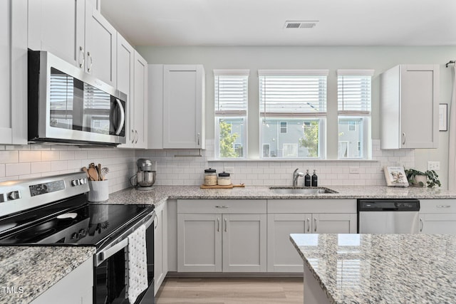 150 Gosford Ln, Garner, NC 27529 - kitchen with stainless steel appliances, plenty of natural light, decorative backsplash, and light wood-style flooring