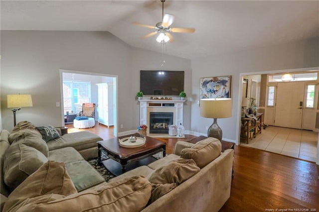 3119 Metthame Dr, Fayetteville, NC 28306 - living room featuring wood finished floors, vaulted ceiling, ceiling fan, a glass covered fireplace, and baseboards
