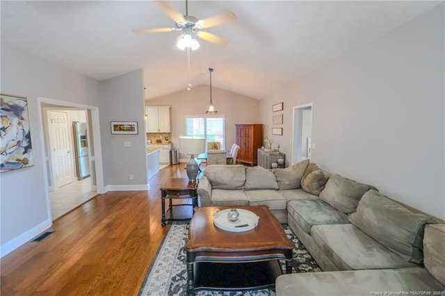 3119 Metthame Dr, Fayetteville, NC 28306 - living room featuring vaulted ceiling, light wood finished floors, a ceiling fan, and baseboards