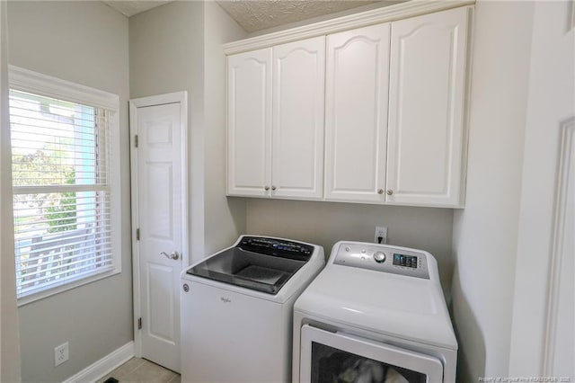 3119 Metthame Dr, Fayetteville, NC 28306 - laundry room featuring independent washer and dryer, cabinet space, baseboards, and light tile patterned floors