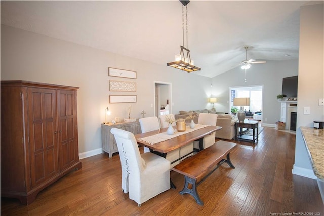 3119 Metthame Dr, Fayetteville, NC 28306 - dining space featuring a ceiling fan, dark wood-style floors, lofted ceiling, and a fireplace with flush hearth