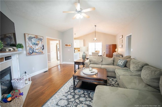 3119 Metthame Dr, Fayetteville, NC 28306 - living area with wood finished floors, lofted ceiling, a ceiling fan, and a glass covered fireplace