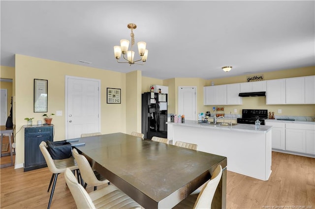 dining space with a chandelier and light wood-style floors