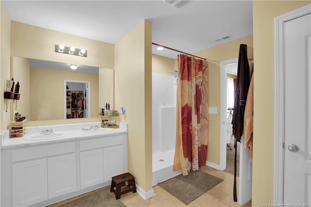 full bath with a shower with curtain, double vanity, baseboards, and tile patterned floors