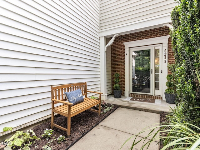 doorway to property featuring brick siding