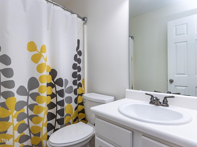 bathroom with toilet, vanity, and curtained shower