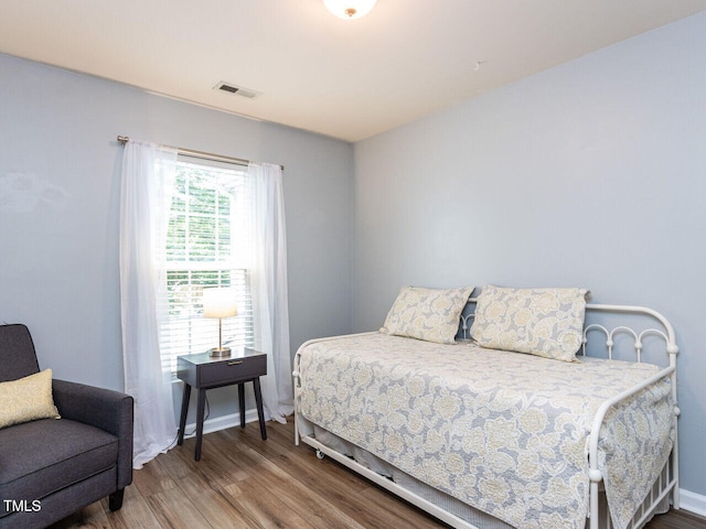 bedroom with wood finished floors and baseboards