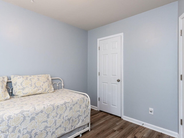 bedroom with wood finished floors and baseboards