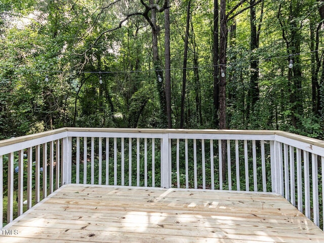 wooden terrace featuring a view of trees