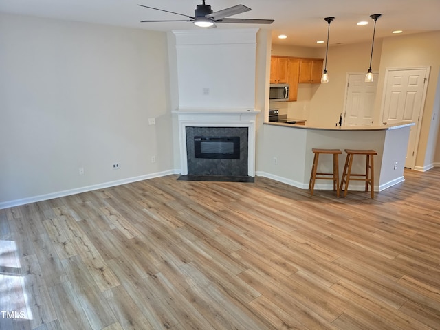 4206 Camden Woods Ct, Raleigh, NC 27612 - unfurnished living room featuring ceiling fan, recessed lighting, light wood-style flooring, baseboards, and a tile fireplace
