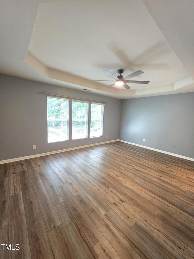 4206 Camden Woods Ct, Raleigh, NC 27612 - unfurnished room with a tray ceiling, a ceiling fan, baseboards, and hardwood / wood-style flooring