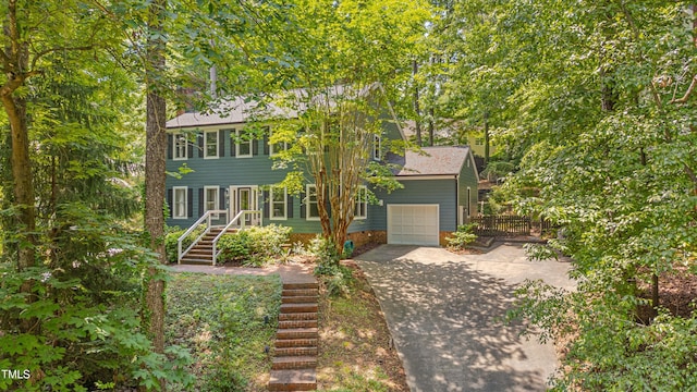 colonial inspired home with driveway, a garage, and fence