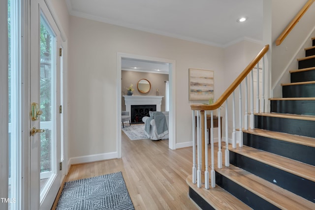 foyer entrance with stairway, wood finished floors, ornamental molding, baseboards, and recessed lighting