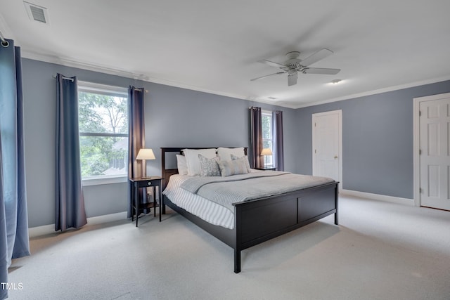 carpeted bedroom featuring baseboards, ornamental molding, and a ceiling fan