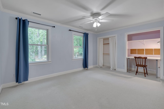 unfurnished bedroom with carpet flooring, crown molding, baseboards, ceiling fan, and a closet