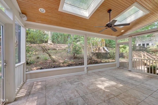 unfurnished sunroom featuring a skylight, vaulted ceiling, and ceiling fan