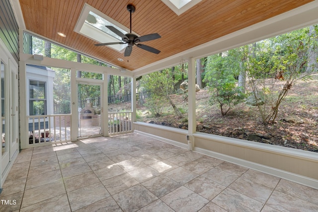 unfurnished sunroom featuring a skylight, ceiling fan, and lofted ceiling