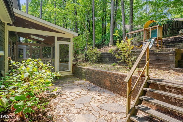 view of patio / terrace featuring a sunroom and fence