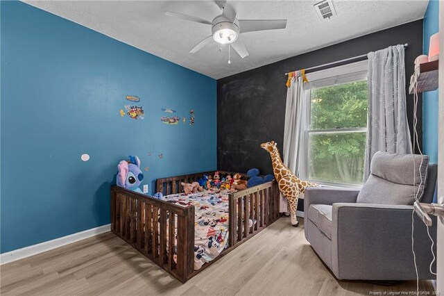5712 Icarus Cir, Fayetteville, NC 28304 - bedroom with wood finished floors, a textured ceiling, ceiling fan, and baseboards