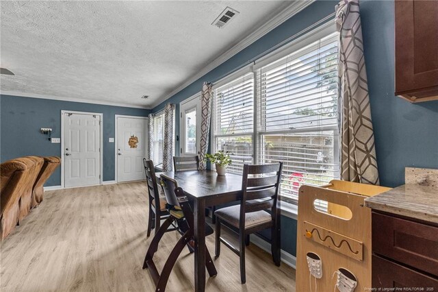 5712 Icarus Cir, Fayetteville, NC 28304 - dining room featuring a textured ceiling, light wood-style floors, ornamental molding, and baseboards