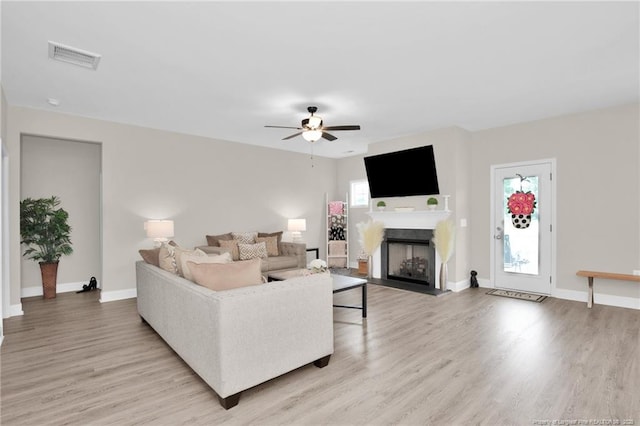 5831 James Allen Ln, Stedman, NC 28391 - living room with light wood-type flooring, a fireplace, a ceiling fan, and baseboards