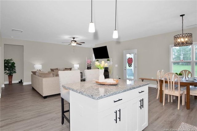 5831 James Allen Ln, Stedman, NC 28391 - kitchen featuring light wood-style flooring, a chandelier, a ceiling fan, and white cabinetry