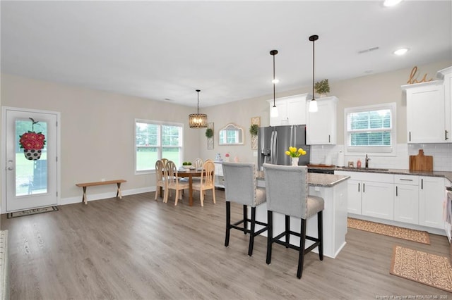 5831 James Allen Ln, Stedman, NC 28391 - kitchen featuring stainless steel fridge with ice dispenser, a sink, tasteful backsplash, a kitchen island, and light wood-style floors