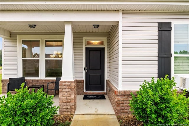 property entrance featuring a porch and cooling unit