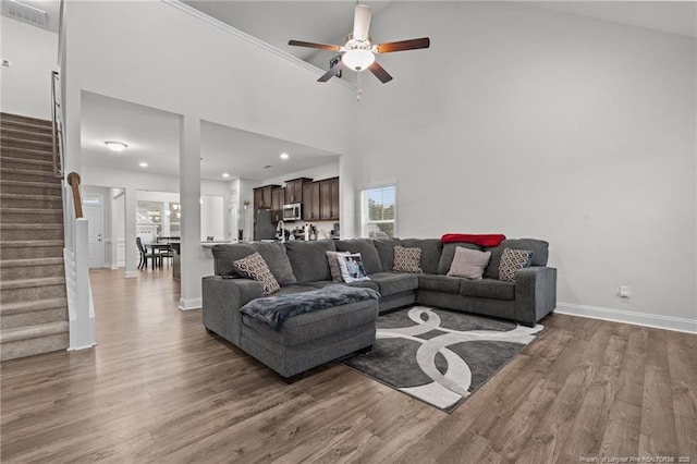 living area featuring ceiling fan, wood finished floors, stairway, baseboards, and recessed lighting