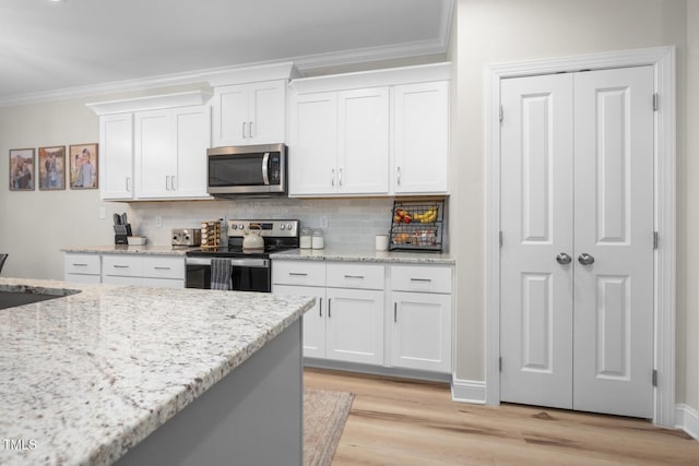 220 Purslane Dr, Franklinton, NC 27525 - kitchen featuring appliances with stainless steel finishes, crown molding, white cabinets, tasteful backsplash, and light wood-style flooring