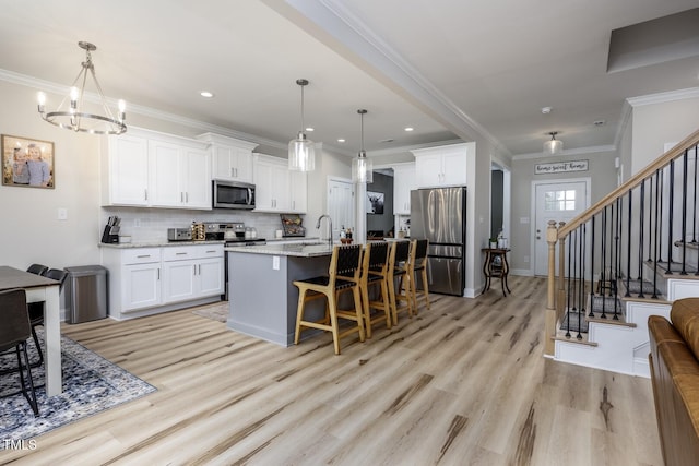 220 Purslane Dr, Franklinton, NC 27525 - kitchen featuring appliances with stainless steel finishes, light wood finished floors, a chandelier, backsplash, and crown molding