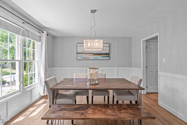 208 Silk Hope Dr, Cary, NC 27519 - dining space with light wood-style floors, a chandelier, a wainscoted wall, and a decorative wall