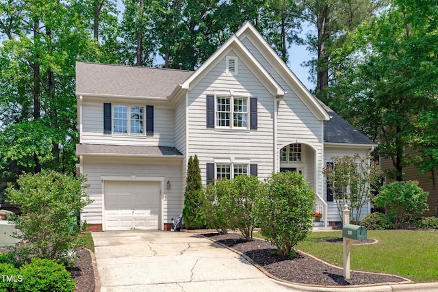 208 Silk Hope Dr, Cary, NC 27519 - traditional-style house featuring an attached garage, driveway, a front lawn, and roof with shingles