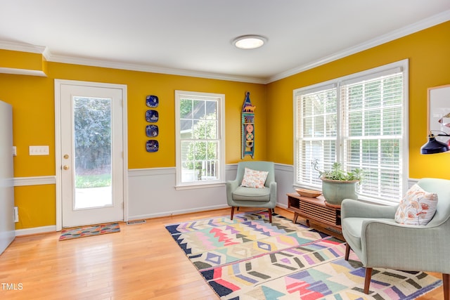 sitting room featuring ornamental molding, wood finished floors, and baseboards