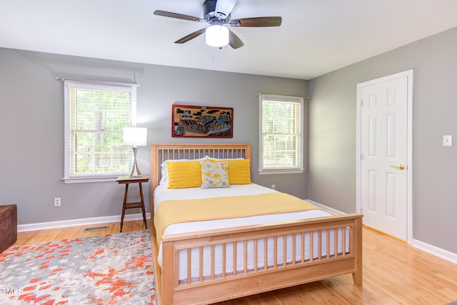 bedroom with wood finished floors, baseboards, and a ceiling fan