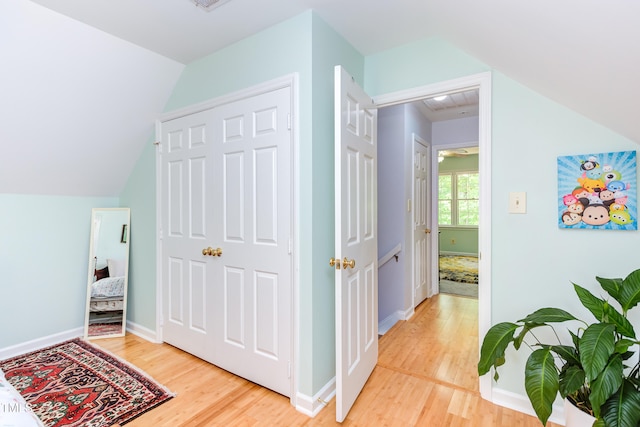 bonus room featuring light wood-type flooring, vaulted ceiling, and baseboards