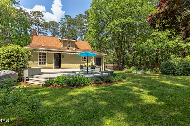 rear view of property featuring a chimney and a deck