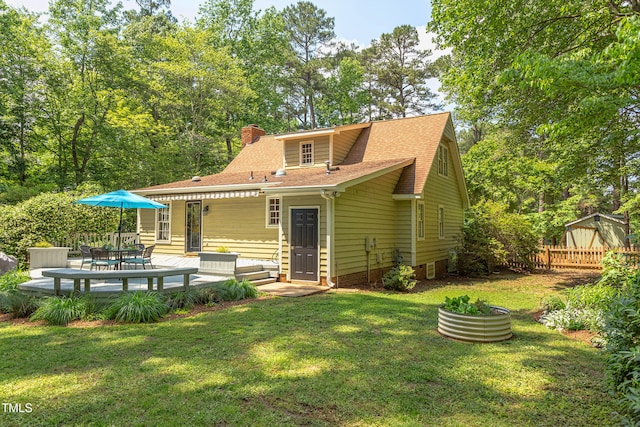 rear view of house featuring a chimney, roof with shingles, and a wooden deck