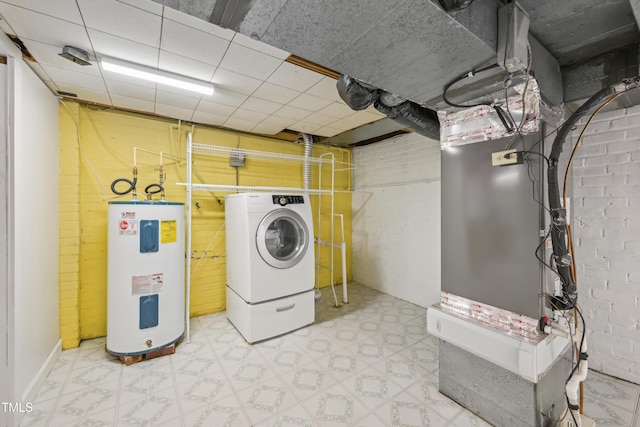 laundry area featuring electric water heater, tile patterned floors, and washer / clothes dryer