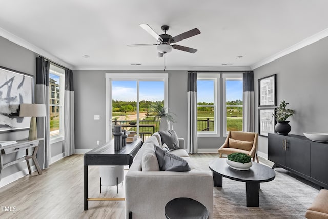 living area with ornamental molding, ceiling fan, light wood-style flooring, and baseboards