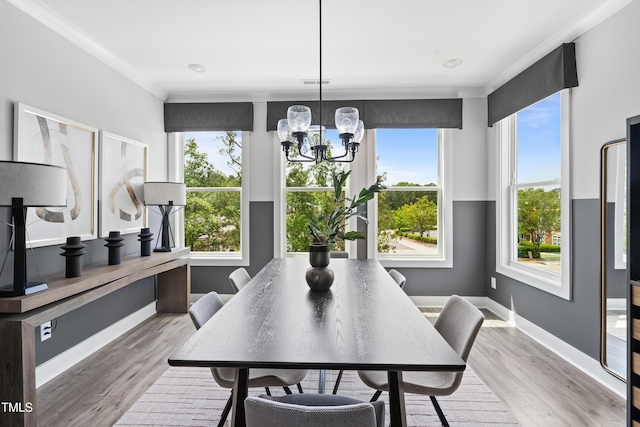 dining space with a chandelier, wood finished floors, baseboards, and ornamental molding