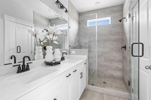 full bathroom featuring healthy amount of natural light, a shower stall, and double vanity