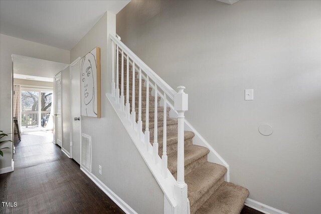 stairway with baseboards and wood finished floors
