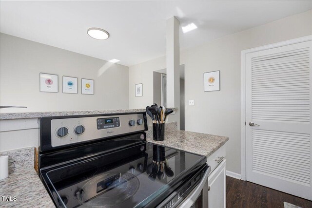 kitchen with electric range, dark wood finished floors, white cabinetry, and light stone countertops