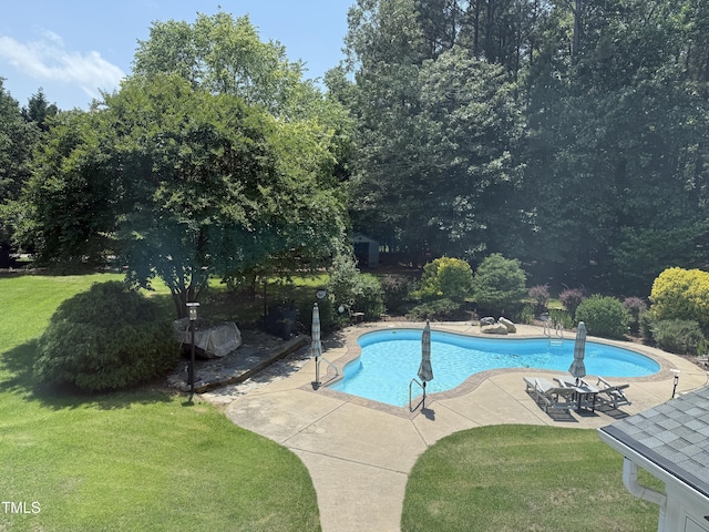 outdoor pool featuring a lawn and a patio