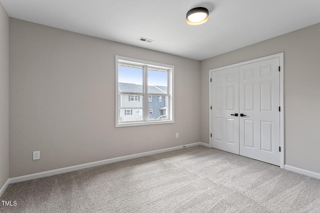 353 E Williams St, Angier, NC 27501 - unfurnished bedroom featuring light colored carpet, baseboards, and a closet
