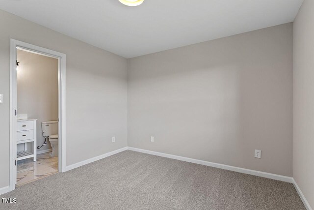 353 E Williams St, Angier, NC 27501 - unfurnished bedroom with carpet floors, baseboards, and connected bathroom