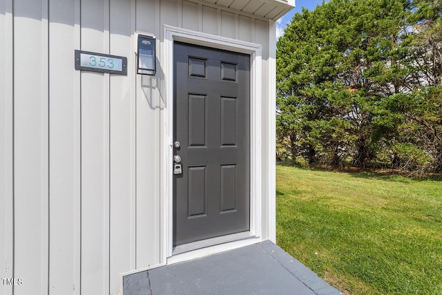353 E Williams St, Angier, NC 27501 - view of exterior entry with board and batten siding and a lawn