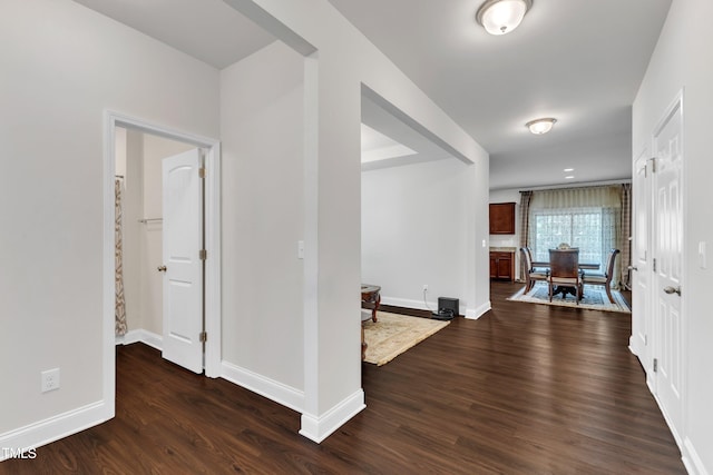 hallway with baseboards and dark wood finished floors