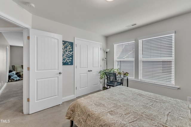 bedroom with carpet floors, baseboards, and a closet